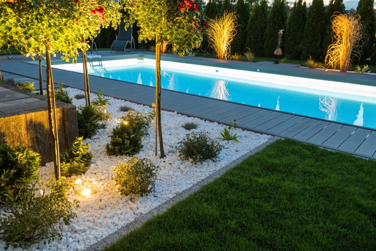 Modern pool showcasing complete refurbishing with updated decking, clean water, and enhanced landscaping.